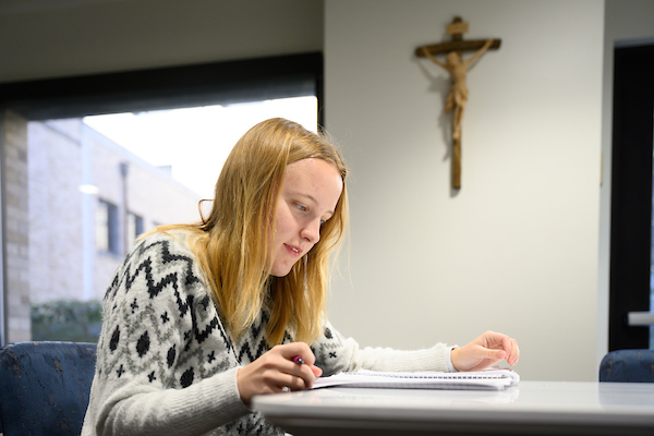 Student studies near crucifix in Department of German and Russian
